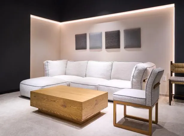 Upholstered sectional and lounge chair in a lit showroom bay